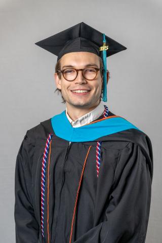 Portrait of Will Barrett wearing graduation regalia