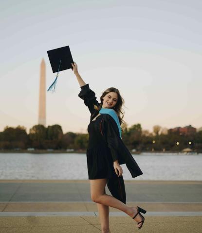 2024 LBJ DC Graduate Emily Barton Emily Barton in graduation cap and gown in front of Washington Monument
