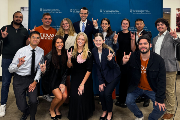 Group of students pose in front of an LBJ Washington Center step-and-repeat